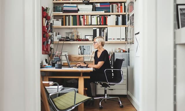 En ældre kvinde, der sidder og arbejder på et hjemmekontor