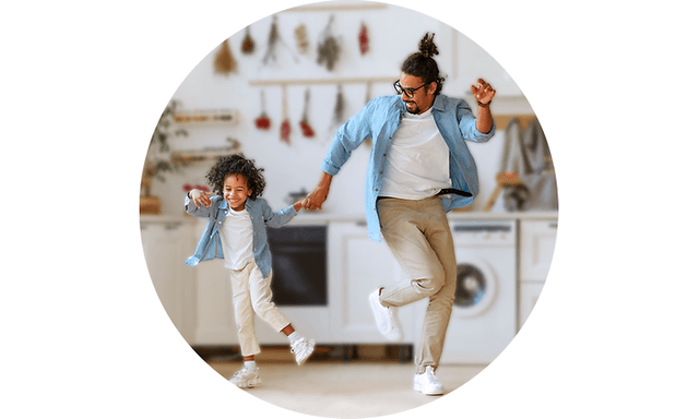 Pappa och barn som dansar i ett kök