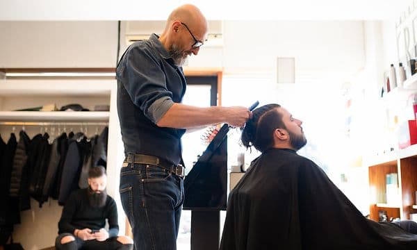 Hairdresser cutting hair on  a man