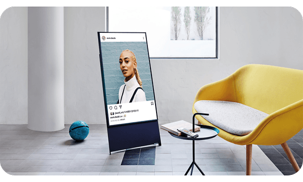 Samsung The Sero Lifestyle TV stående vertikalt ved siden av gul stol