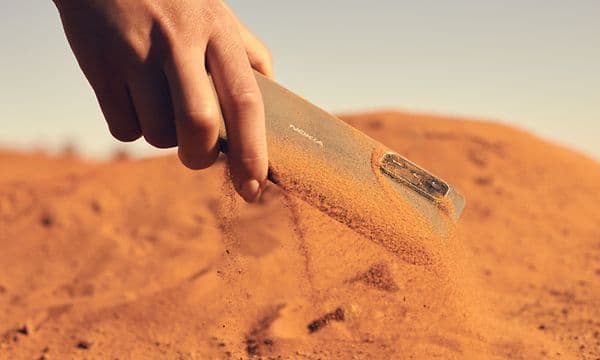Støvtæt NokiaXR21-telefon bliver samlet op fra sand