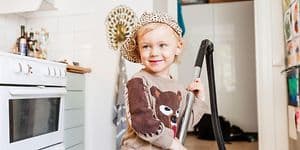 Kid with vacuum cleaner in a kitchen
