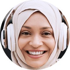 Ung kvinde der bærer høretelefoner udover sin hijab og smiler til kameraet