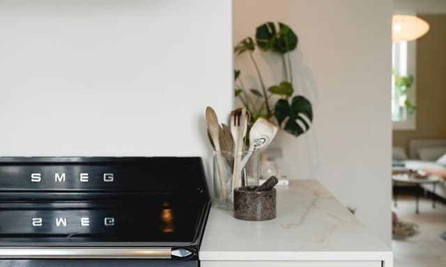 Smeg-liesi valkoisenvärisessä Epoq-keittiössä