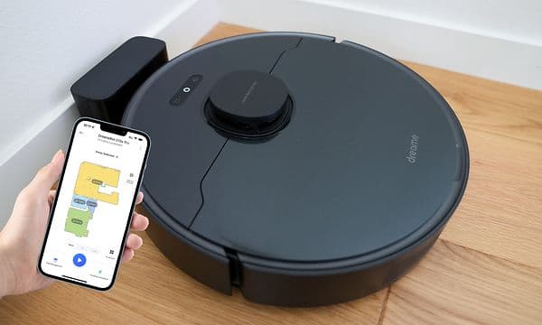 Dreame D10s Pro robotstøvsuger og en hånd som kontroller rengjøringen via DreamHome-appen