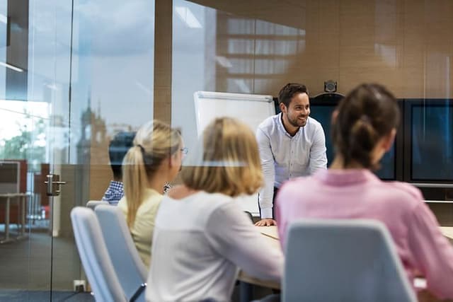 B2B - Personer der sidder i et mødelokale og deltager i det møde