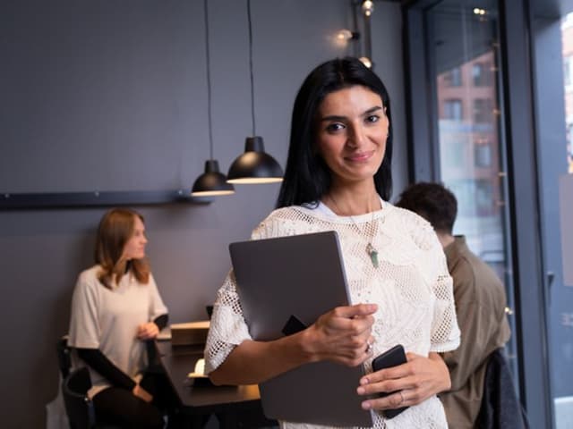 B2B - Woman posing for the camera with people in the background