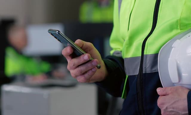 Tåliga telefoner: En smartphone i handen på en byggarbetare.