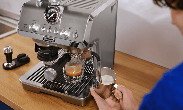 En person som använder The My LatteArt ångstav på en DeLonghi La Specialista Arte Evo kaffemaskin