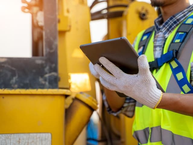 B2B - Tablet - Man standing at a construction site using a tablet with gloves