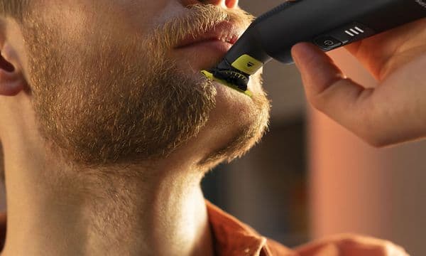 Lähikuva miehestä, joka trimmaa partaansa Philips OneBlade Pro 360 -parranajokoneella
