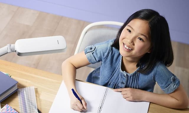 Philips skrivebordslampe og en pige ved et skrivebord