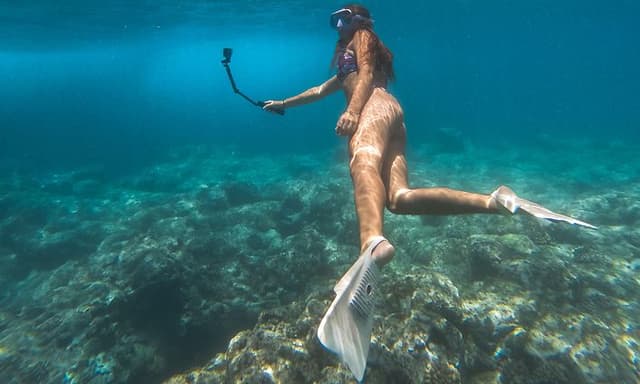Dame som snorklerer under vann med GoPro HERO12 Black