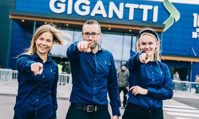 Gigantin henkilökuntaa osoittavat sormella kohti kameraa