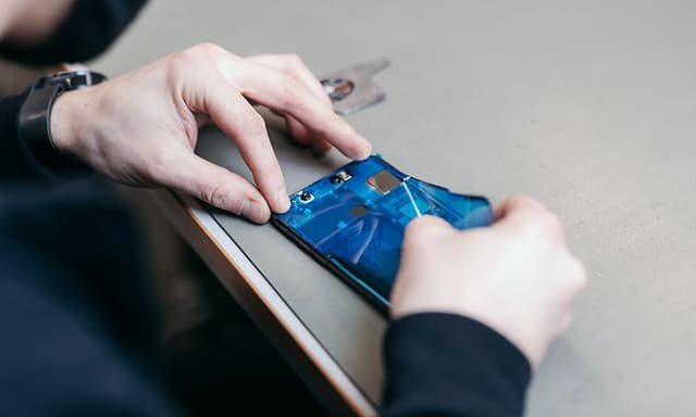 Hands placing screen saver on mobile phone