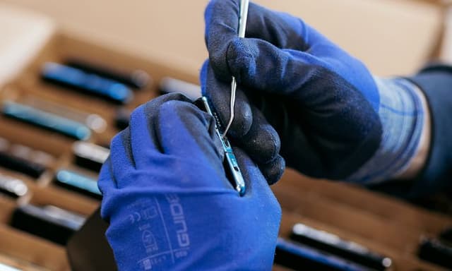 Person using reparing tools on used mobile phone