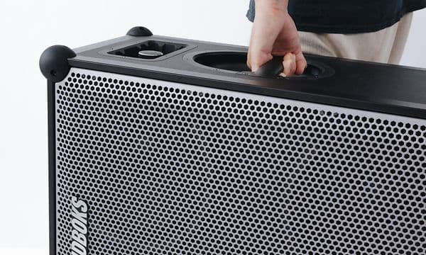 Mann som bærer SOUNDBOKS 4 i håndtaket