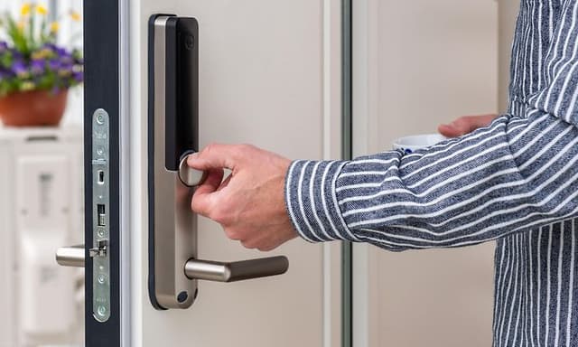 Smart home - smart home security - man's hand on an electronic door lock
