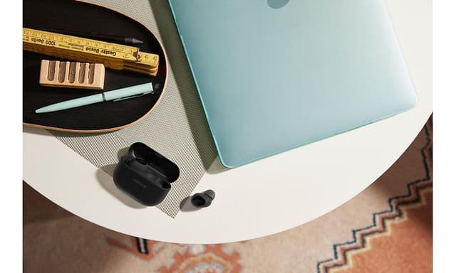 Jabra Elite 10 ved siden af en laptop