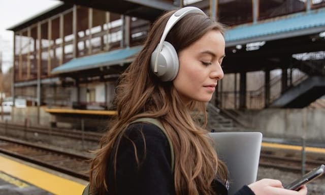 Woman with headphones on train station