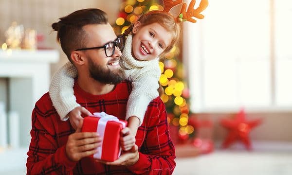 Ett barn ger en julklapp till sin pappa