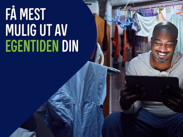 Man has escaped to a laundry room with his tablet. Banner text: Få mest mulig ut av egentiden din