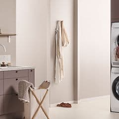 EPOQ - Kodinhoitohuone - Sisutukseltaan beigen sävyinen kodinhoitohuone, jossa integroidut pesukone ja kuivausrumpu