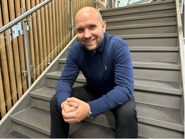 Mig-tid - Ambassadør Christian i blå Elgiganten-skjorte på en trappe