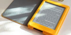 Kobo e-bogslæser med gult etui på et bord