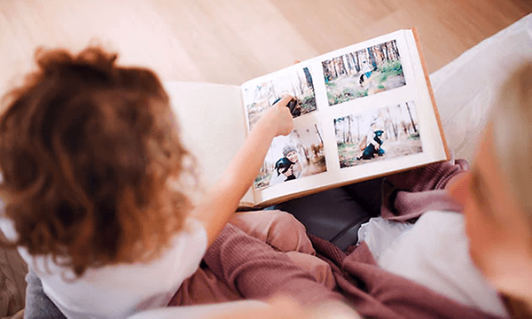 en kvinde og et barn kigger i et fotoalbum sammen