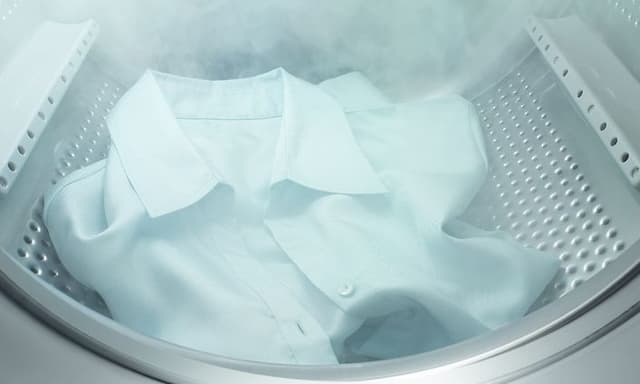 En hvit skjorte blir dampet inne i en Electrolux-vaskemaskin