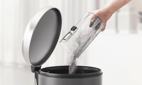 The Samsung Jet 75's dust container being easlily emptied into the trash