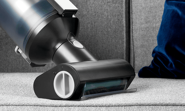 Henkilö imuroi sohvaa Apt Sonic 750 -rikkaimurilla, johon kiinnitetty Turbo brush -lisäosa