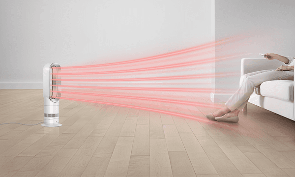 Illustrasjon av Dyson Hot+cool Jet Focus vifteovn som sender ut varm luft mot en person som sitter i en sofa