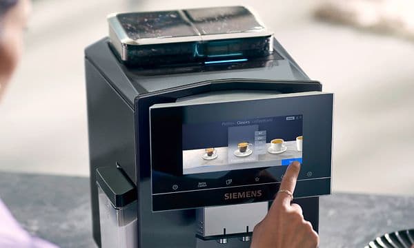 Kvinne velger kaffe på touchskjermen til en Siemens EQ900 kaffemaskin