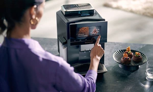 Kvinne bruker touchskjermen på en Siemens EQ900 kaffemaskin