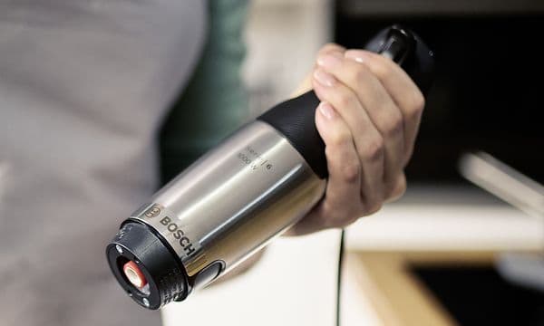 Kvinna som håller Bosch ErgoMaster Series 6 stavmixers motordel i handen