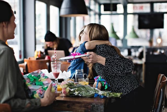 Banner med mennesker på cafe der giver hianden gaver