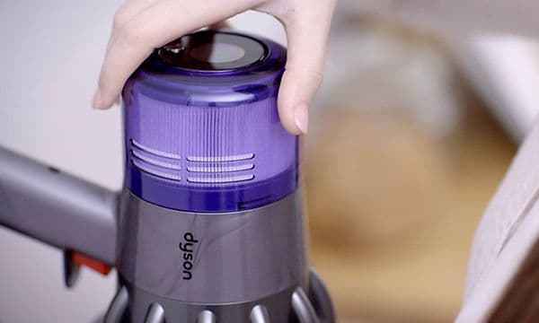 Person, der skruer eftermotorfilteret af på en Dyson-støvsuger