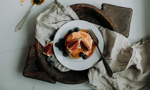 Pancake Day 2024 - Stack of pancakes with syrup, figs, and blueberries