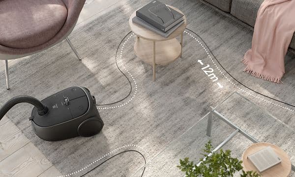 Electrolux Clean 600 Bagged vacuum cleaner in black in living room showing its 12 metre radius
