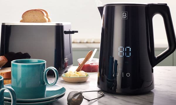 F&B -vedenkeitin digitaalisella näytöllä, sekä F&B -leivänpaahdin keittiön työtasolla aamiastarvikkeiden kera