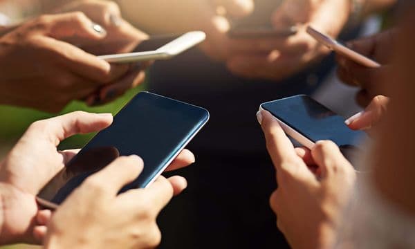 En grupp människor som använder sina smartphones