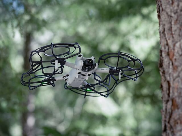 Computing - DJI - DJI Mini 4 Pro med beskyttelseskanter, der flyver i skoven