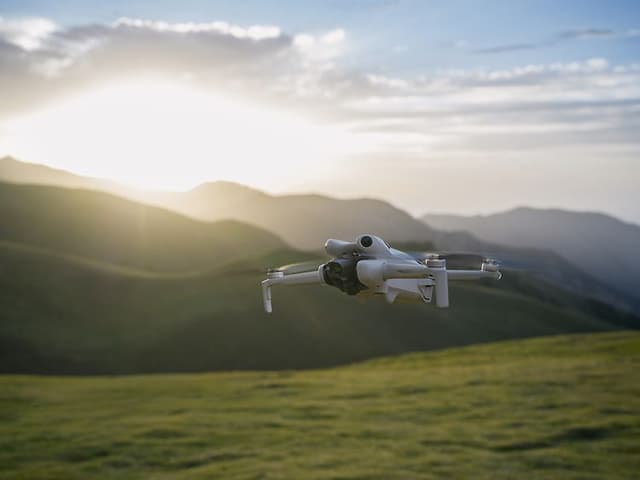 Computing - DJI - DJI Mini 4 Pro flyr foran et landskap