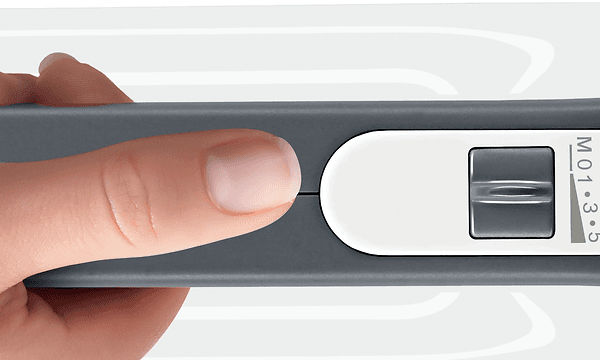Nainen pitelee Bosch StyLine -sähkövatkainta kädessään, peukalo nopeudensäätimen vieressä