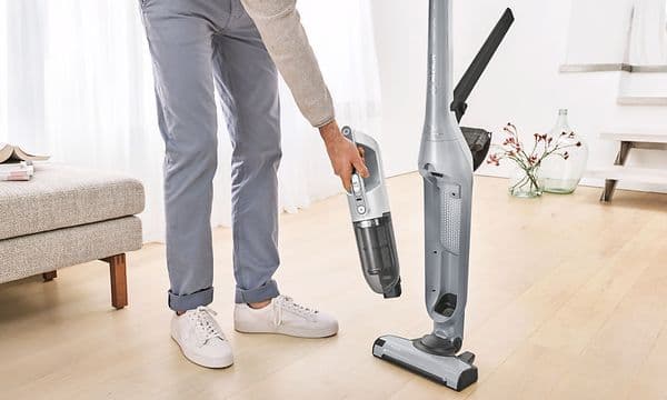 Woman setting the handheld unit back into the cordless Bosch vacuum cleaner's body