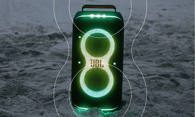 JBL Partybox Stage 120 med lyseffekter på en sandstrand