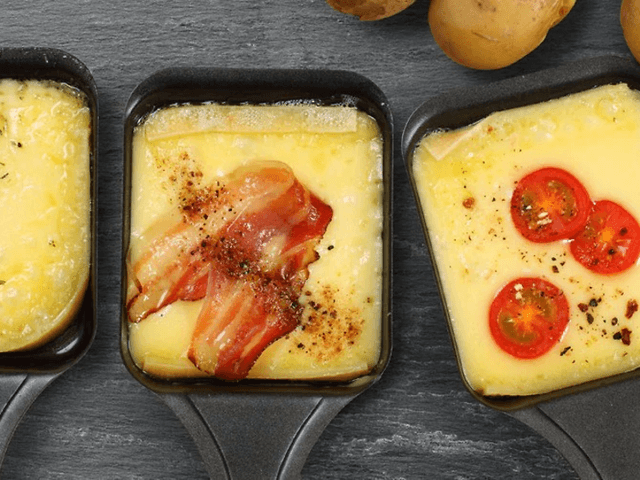 Tre raclette-jern med ost og topping