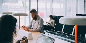 Man and woman working on laptop and tablet at the airport